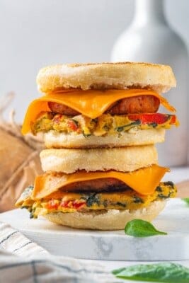 Two vegan breakfast sandwiches stacked on marble board