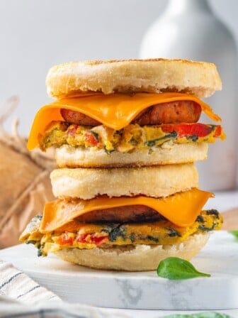 Two vegan breakfast sandwiches stacked on marble board