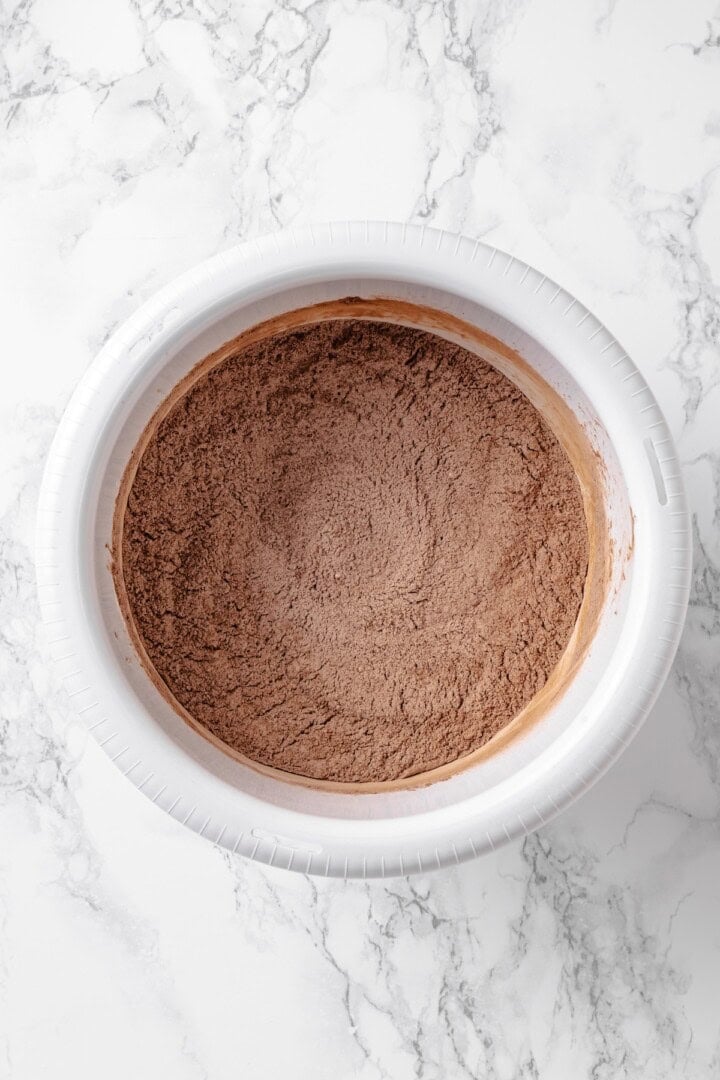 Fluffy chocolate cake, a jammy strawberry filling, strawberry buttercream and chocolate ganache make this Chocolate Strawberry Cake the best! Overhead view of dry cake ingredients in mixing bowl