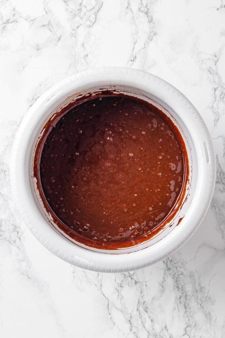 Fluffy chocolate cake, a jammy strawberry filling, strawberry buttercream and chocolate ganache make this Chocolate Strawberry Cake the best! Overhead view of chocolate cake batter in bowl