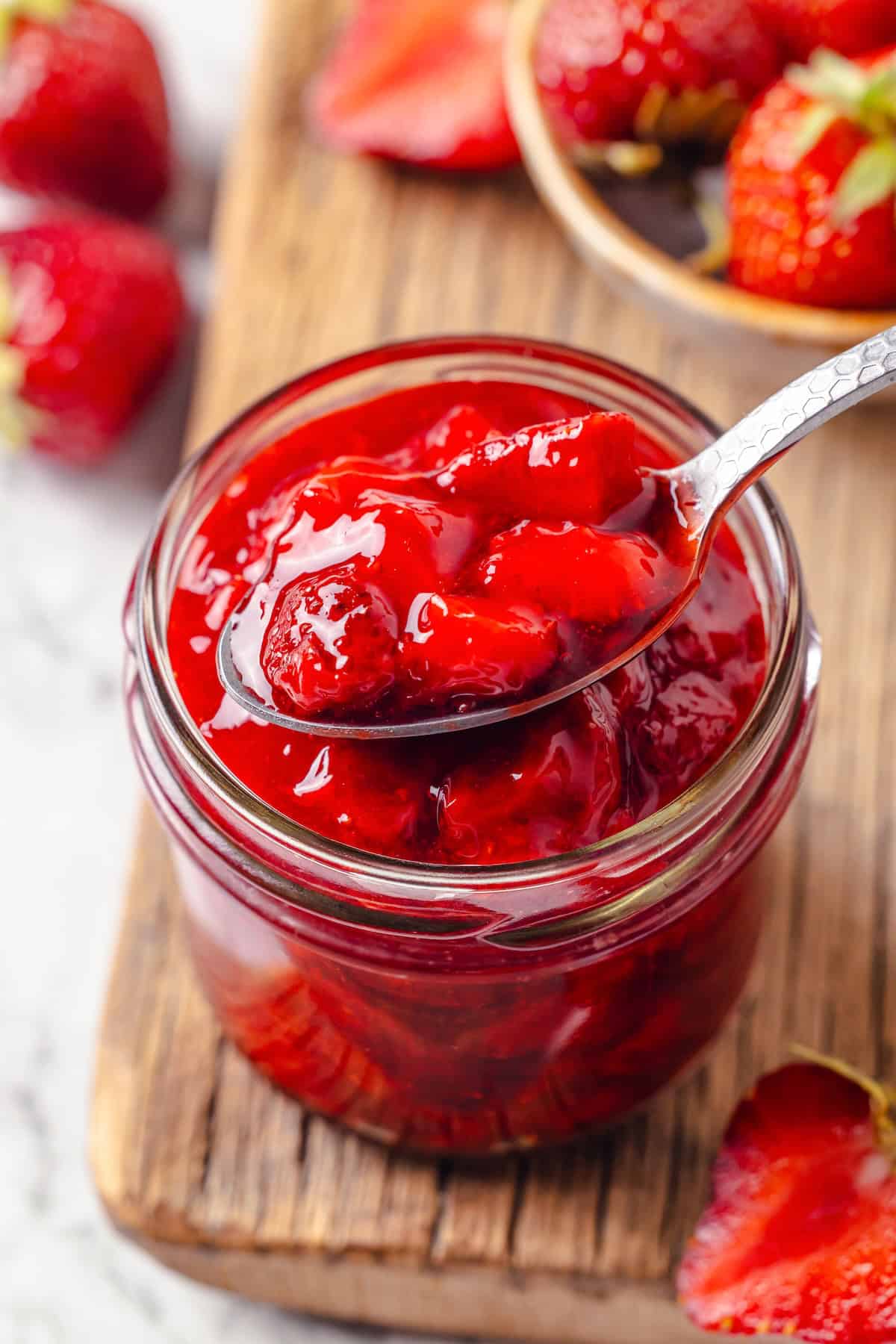 Spoonful of strawberry cake filling in jar