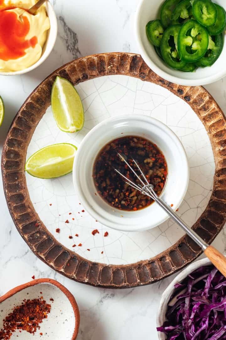 Nuoc cham sauce in bowl with small whisk.