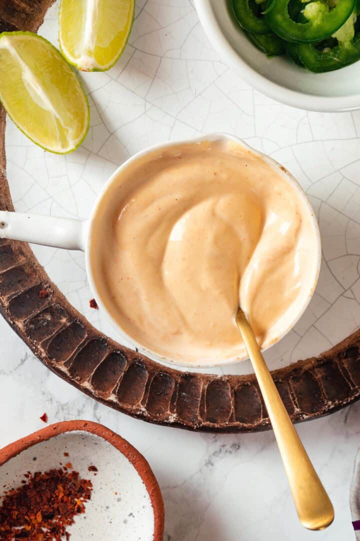 Sriracha mayo in measuring cup with spoon.