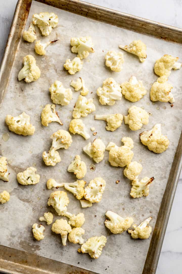 Roasted cauliflower on parchment-lined sheet pan.