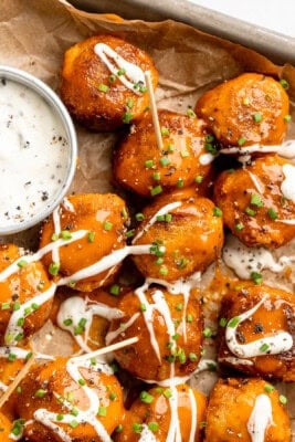 Sheet pan with Buffalo cauliflower meatballs and vegan ranch.