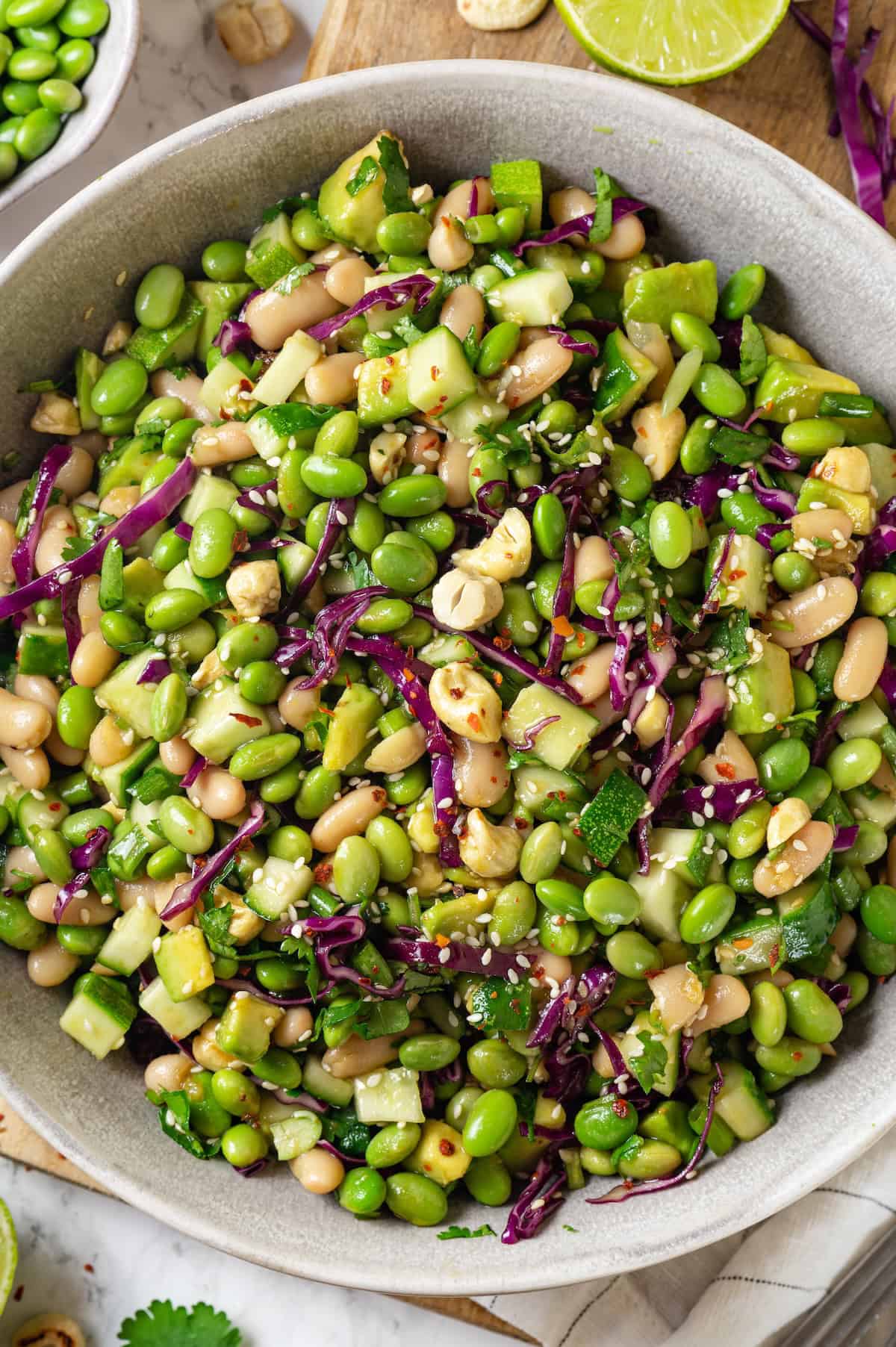 Bowl of edamame salad with cashews, cabbage, and veggies.