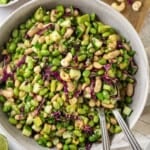 Edamame salad in bowl with two spoons.