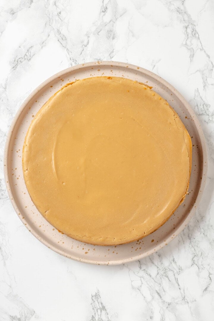 Biscoff cheesecake on cake plate before adding decorations.
