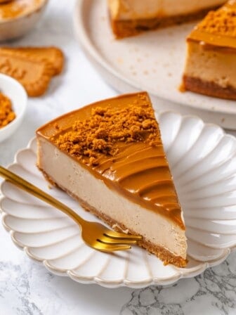Slice of vegan Biscoff cheesecake on plate with fork.
