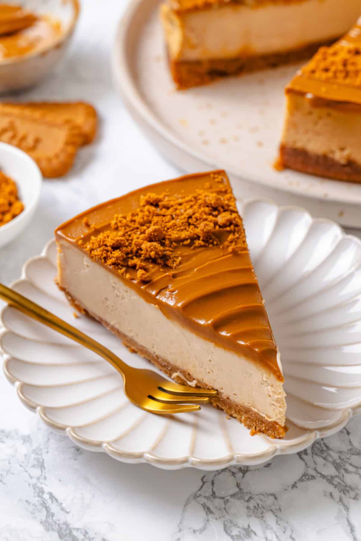 Slice of vegan Biscoff cheesecake on plate with fork.