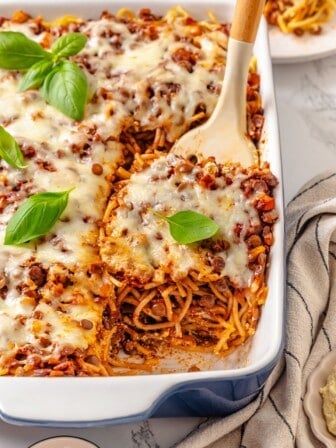 Spatula lifting portion of million dollar spaghetti from pan.