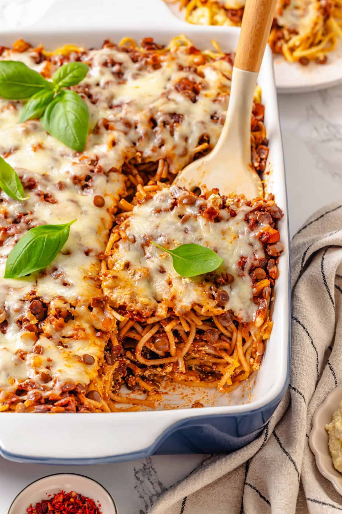Spatula lifting portion of million dollar spaghetti from pan.