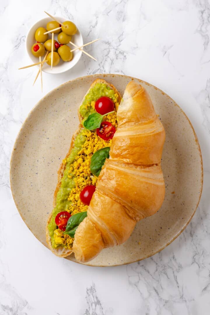 Overhead view of monster breakfast sandwich with avocado slime, tofu scramble, and veggies
