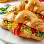 Two vegan monster breakfast sandwiches on marble board
