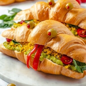Two vegan monster breakfast sandwiches on marble board