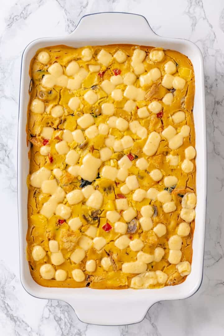 Overhead view of vegan overnight breakfast strata in baking dish before garnishing