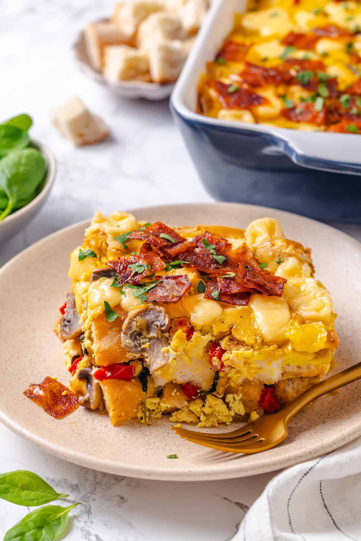 Slice of vegan overnight breakfast strata on plate with fork
