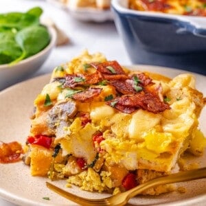 Slice of vegan overnight breakfast strata on plate with fork