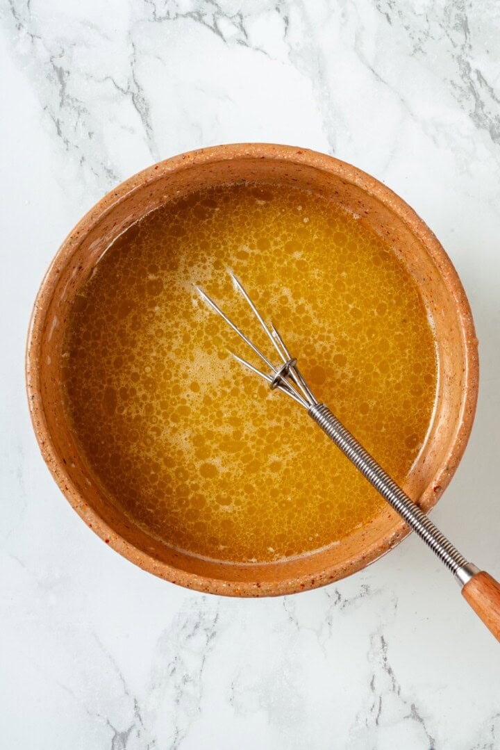 Melted vegan butter in bowl with whisk.