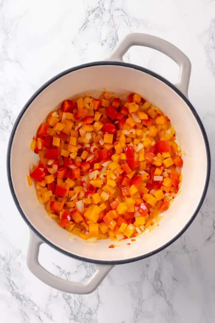 Peppers and onions cooking in Dutch oven.