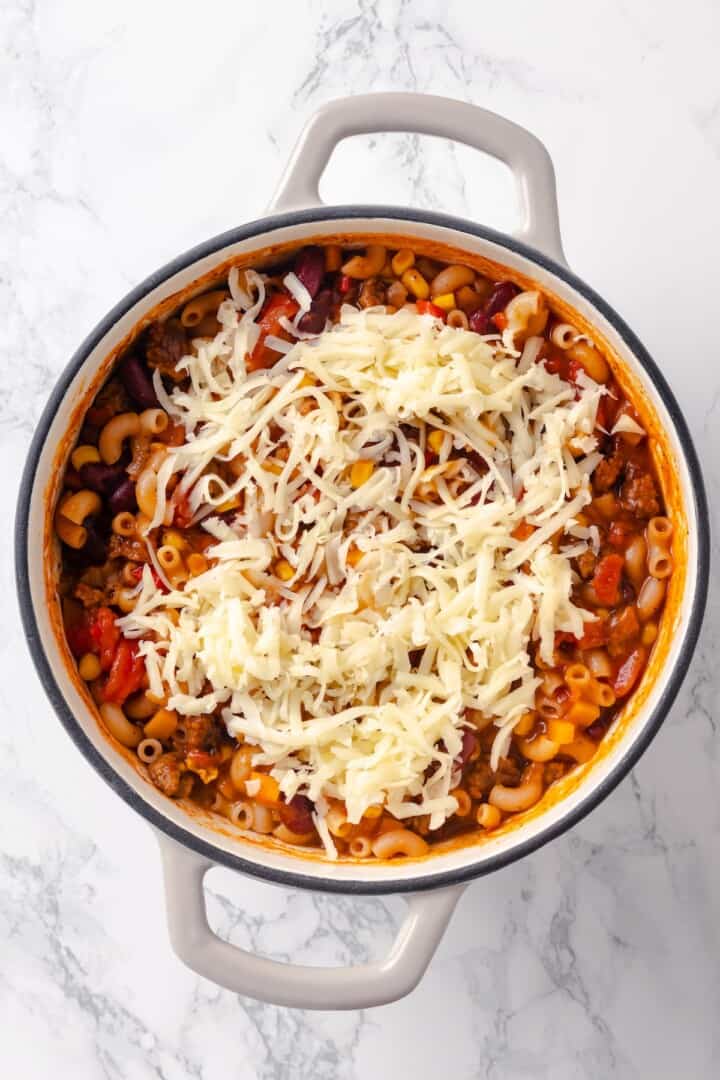 Vegan cheese added to pot of chili mac and cheese.