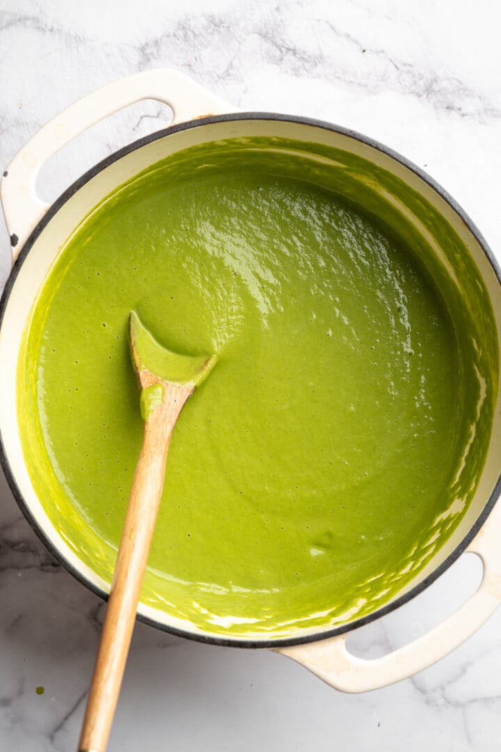 Eliminate waste and make a delicious dinner with this Broccoli Fridge Clean-Out Soup! Rich and creamy, with optional grilled cheese croutons. Dutch oven with broccoli fridge clean-out soup and wooden spoon.