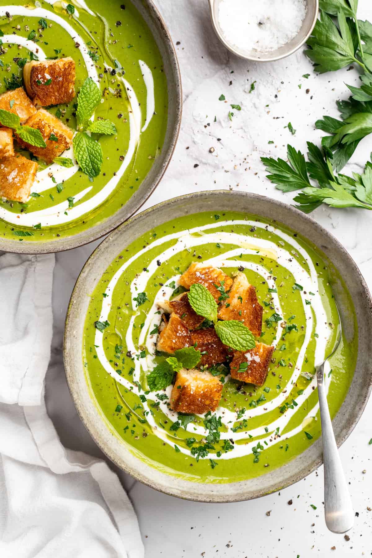 Eliminate waste and make a delicious dinner with this Broccoli Fridge Clean-Out Soup! Rich and creamy, with optional grilled cheese croutons. Two bowls of broccoli fridge clean-out soup with grilled cheese croutons.