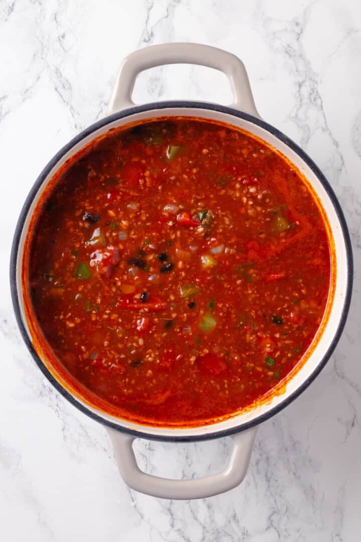 This Stuffed Pepper Soup is a satisfying vegan meal, with walnut “meat,” green peppers, rice and veggies in a rich tomato broth. Delicious! Stuffed pepper soup in Dutch oven before adding rice.