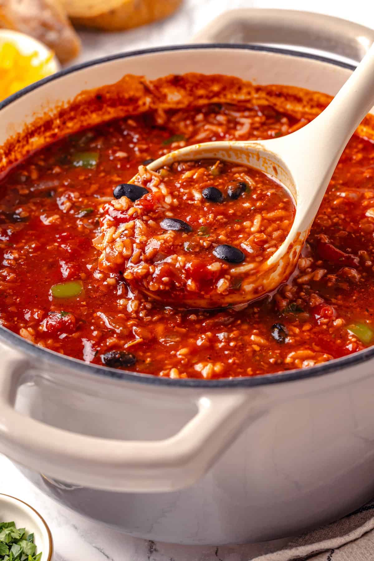 This Stuffed Pepper Soup is a satisfying vegan meal, with walnut “meat,” green peppers, rice and veggies in a rich tomato broth. Delicious! Ladle of vegan stuffed pepper soup.
