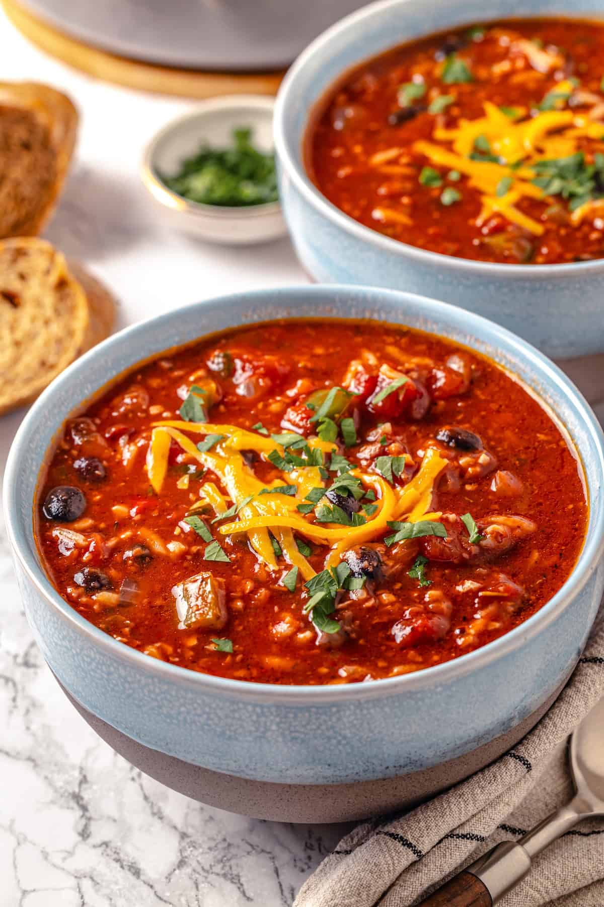 This Stuffed Pepper Soup is a satisfying vegan meal, with walnut “meat,” green peppers, rice and veggies in a rich tomato broth. Delicious! Two bowls of vegan stuffed pepper soup.