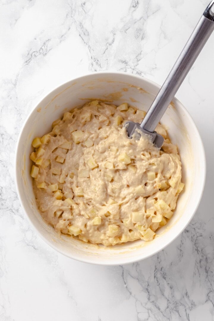 Dough for apple fritters in mixing bowl.