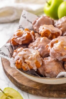 Bowl of homemade vegan apple fritters with glaze.