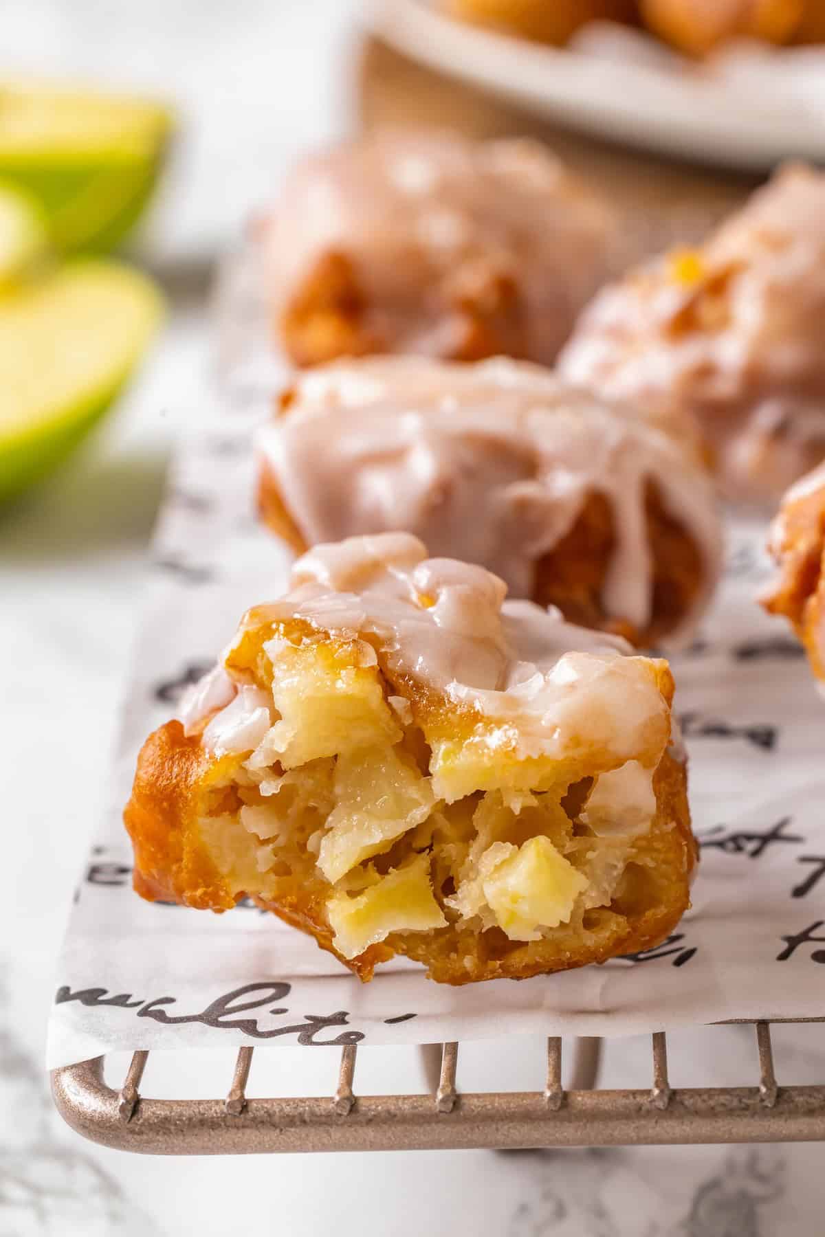 Apple fritter torn open to show tender apples inside.
