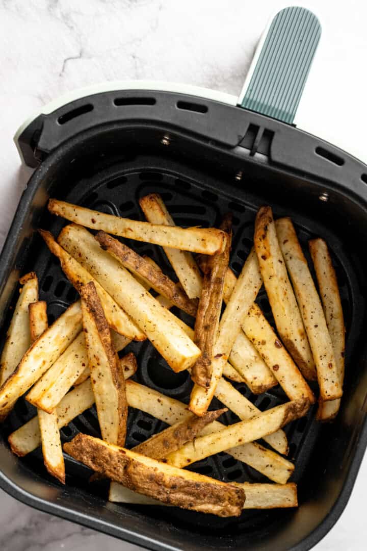 French fries in air fryer basket.