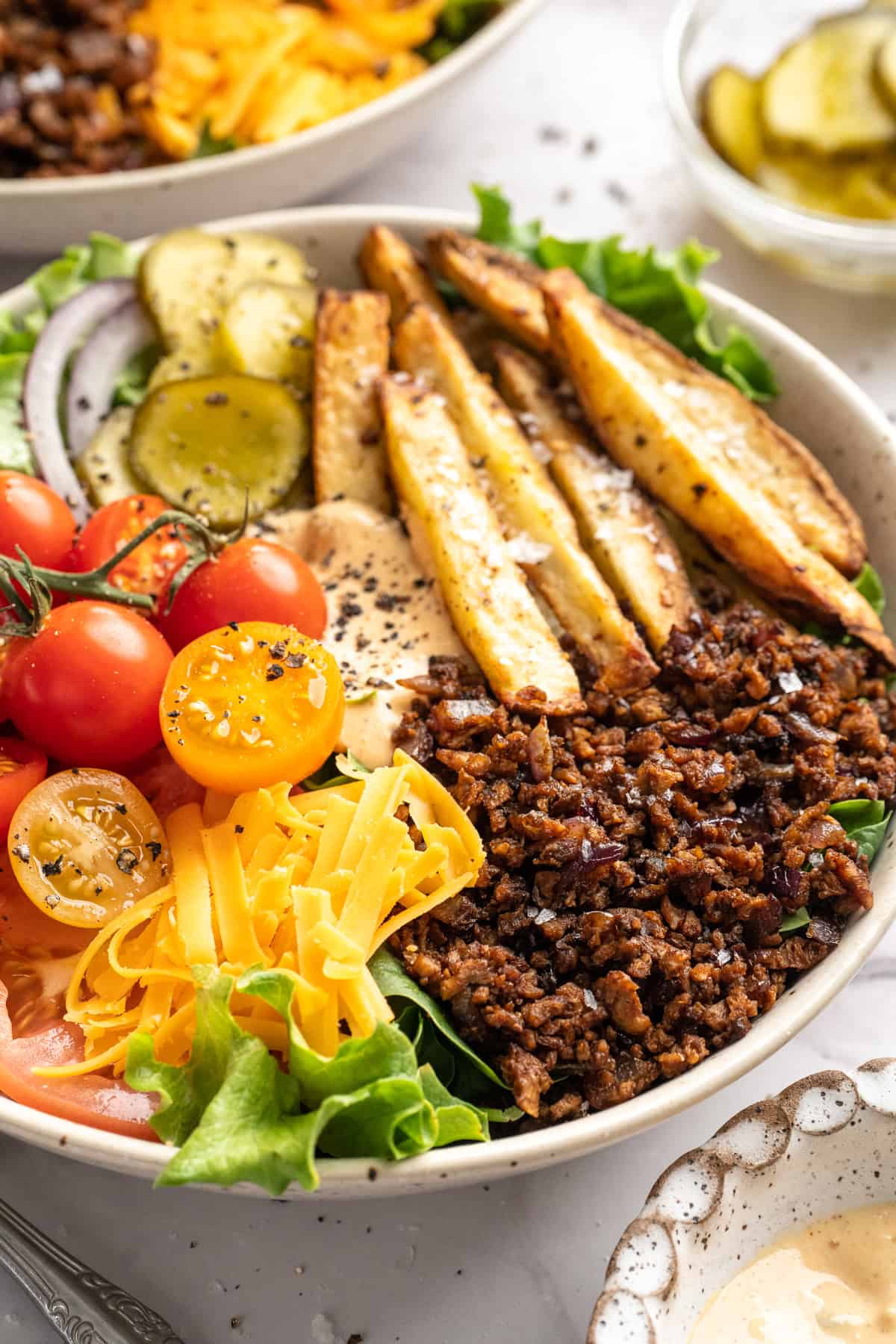 Vegan cheeseburger bowl with fries.