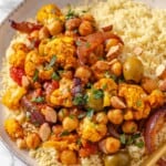 Bowl of couscous topped with Moroccan cauliflower tagine.