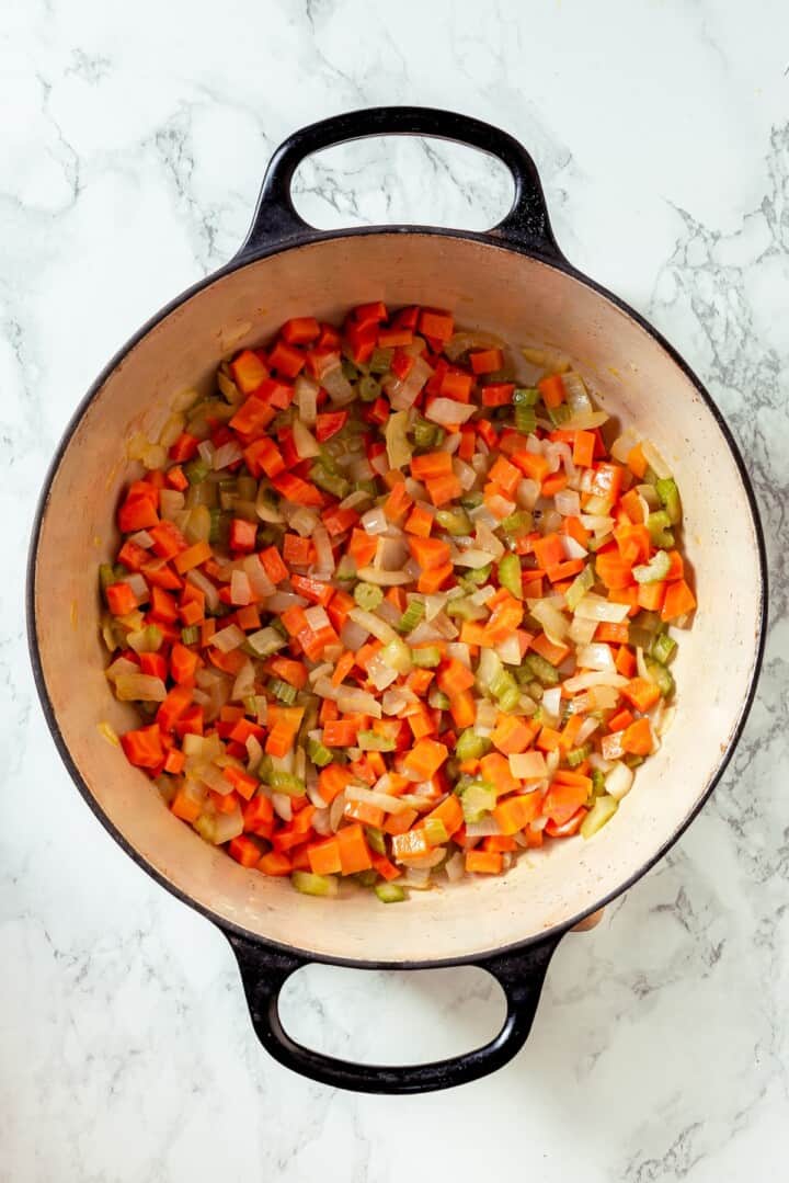 With sweet corn, tender potatoes and a creamy broth, this vegan Corn Chowder recipe is every bit as delicious as the traditional version! Softened carrot, celery, and onion in Dutch oven.