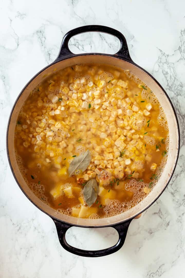 With sweet corn, tender potatoes and a creamy broth, this vegan Corn Chowder recipe is every bit as delicious as the traditional version! Corn chowder simmering in Dutch oven.