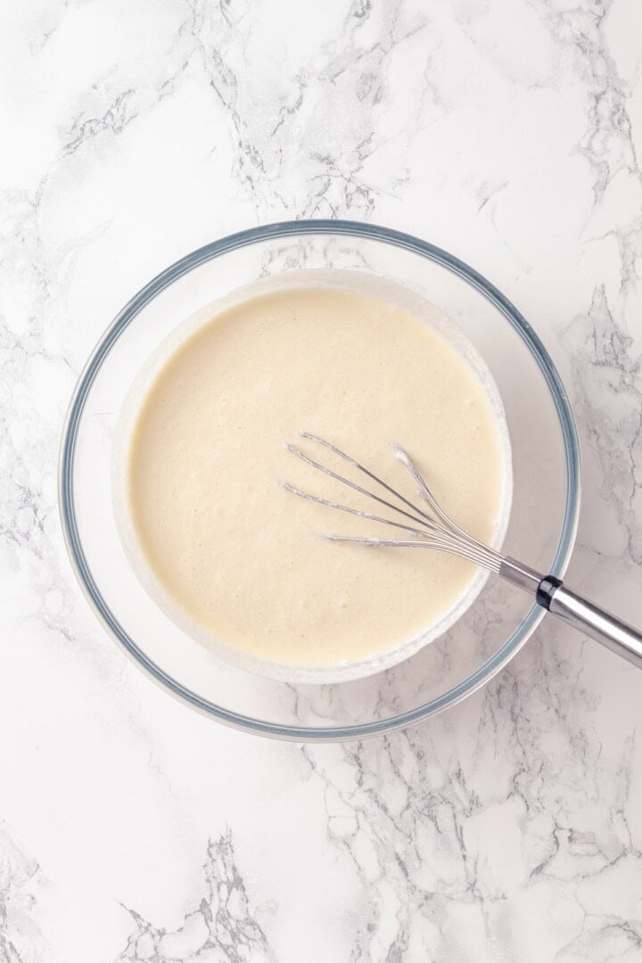 With a rich vegan custard and caramel, this Creme Brûlée French Toast has the flavour of the classic dessert in crowd-pleasing breakfast form! Vegan custard in glass bowl with whisk.