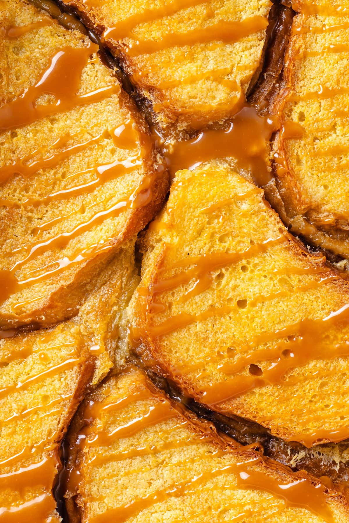 With a rich vegan custard and caramel, this Creme Brûlée French Toast has the flavour of the classic dessert in crowd-pleasing breakfast form! Closeup of creme brulee French toast casserole with caramel drizzle.