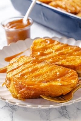 Two slices of creme brulee French toast on plate with caramel drizzle.