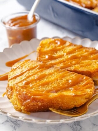 Two slices of creme brulee French toast on plate with caramel drizzle.