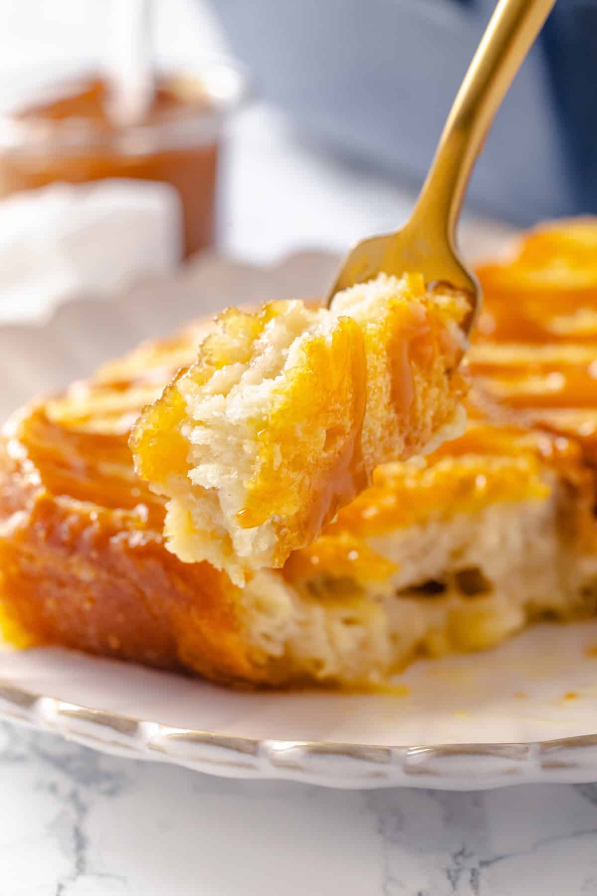 With a rich vegan custard and caramel, this Creme Brûlée French Toast has the flavour of the classic dessert in crowd-pleasing breakfast form! Forkful of creme brulee French toast held over plate.