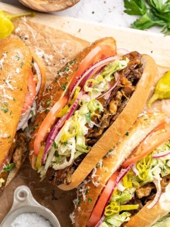 Vegan grinder sandwiches on wooden board.