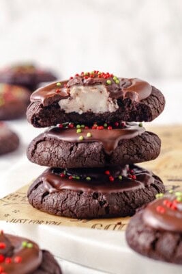 Stack of 3 hot chocolate cookies with top cookie bitten into to show marshmallow.