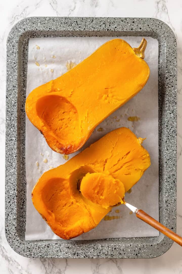 With layers of creamy squash, spinach ricotta and vegan cheese, this butternut squash lasagna is hearty, rich and full of cozy fall flavour! Spoon scooping flesh from roasted butternut squash.