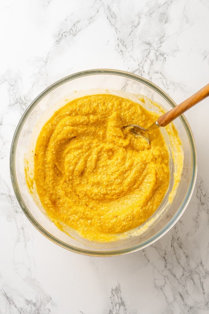 With layers of creamy squash, spinach ricotta and vegan cheese, this butternut squash lasagna is hearty, rich and full of cozy fall flavour! Butternut squash mixture in bowl with spoon.