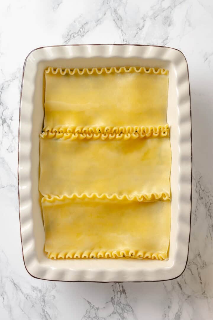 With layers of creamy squash, spinach ricotta and vegan cheese, this butternut squash lasagna is hearty, rich and full of cozy fall flavour! Lasagna noodles in baking dish.