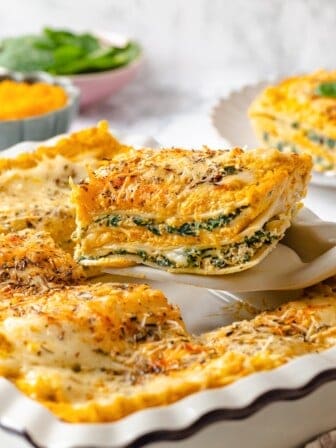 Spatula lifting slice of butternut squash lasagna from casserole dish.