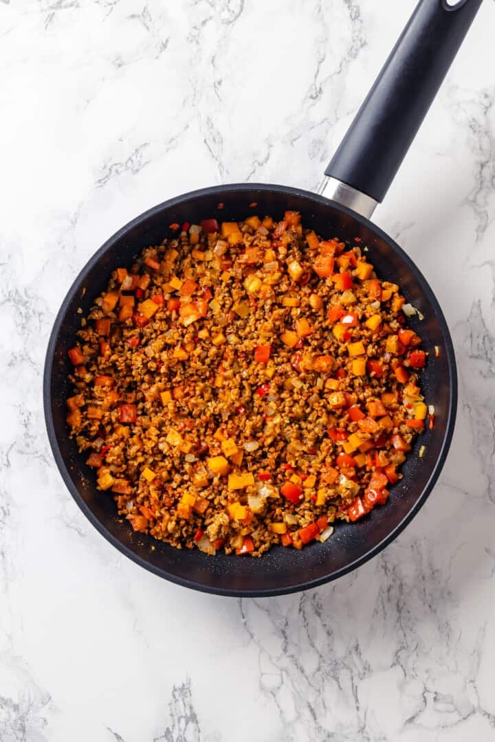 Vegan ground meat and veggies in pan.